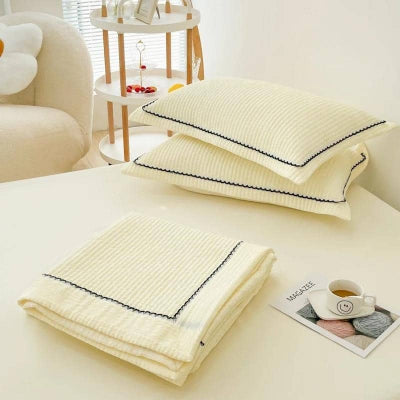 couette ete et oreillers jaune sur lit