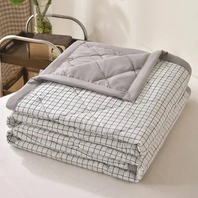 couverture ete grise pliee sur lit