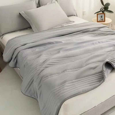 couverture grise sur lit vue cote