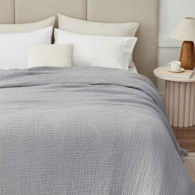 couverture grise sur lit vue face