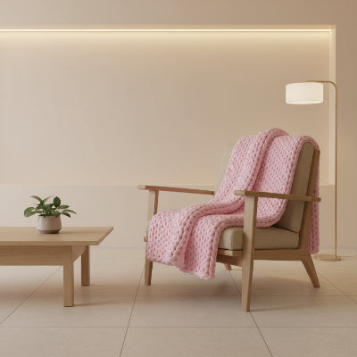 couverture lestee roulee rose pale sur fauteuil