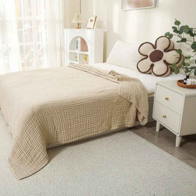 couverture mousseline sur lit beige