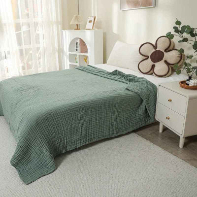 couverture mousseline vert sur lit