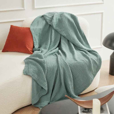 couverture mousseline verte sur canape