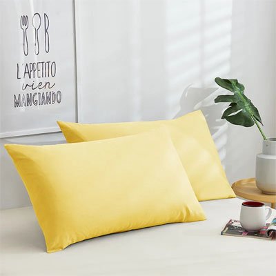 deux taies d oreillers jaune sur lit