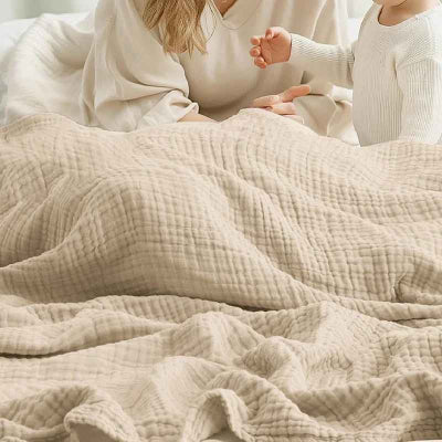 feme avec bebe sous couverture beige