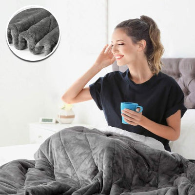 femme assis sur lit avec couverture lestee gris