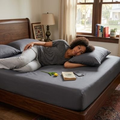 Drap housse femme etendue sur drap housse gris fonce