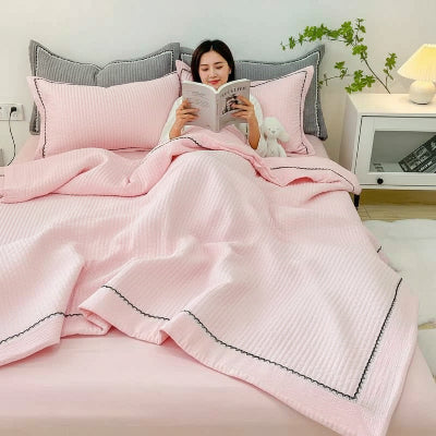 femme lit sous couette ete rose