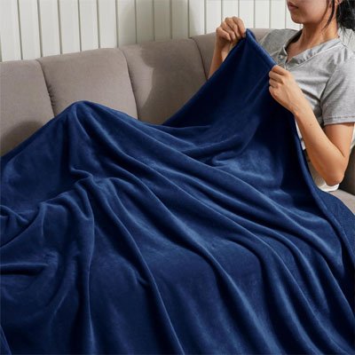 femme sur canapé avec couverture polaire bleu foncé