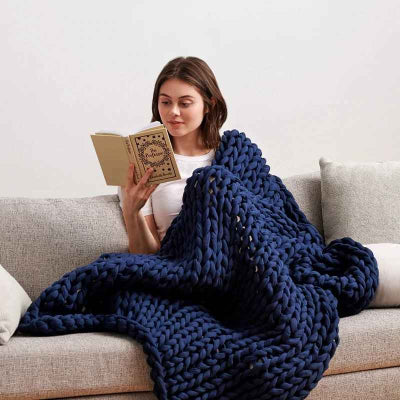 femme sur canape avec couverture lestee bleu fonce