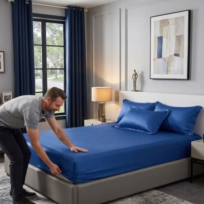 homme installe drap housse satin bleu