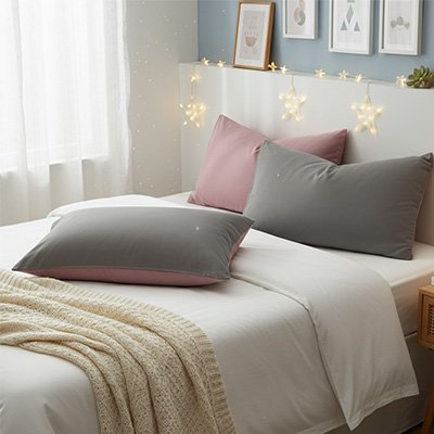 taie d'oreiller rose et gris sur lit