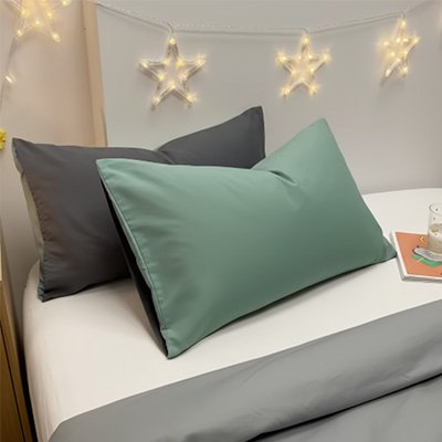 taie d'oreiller vert et gris sur lit